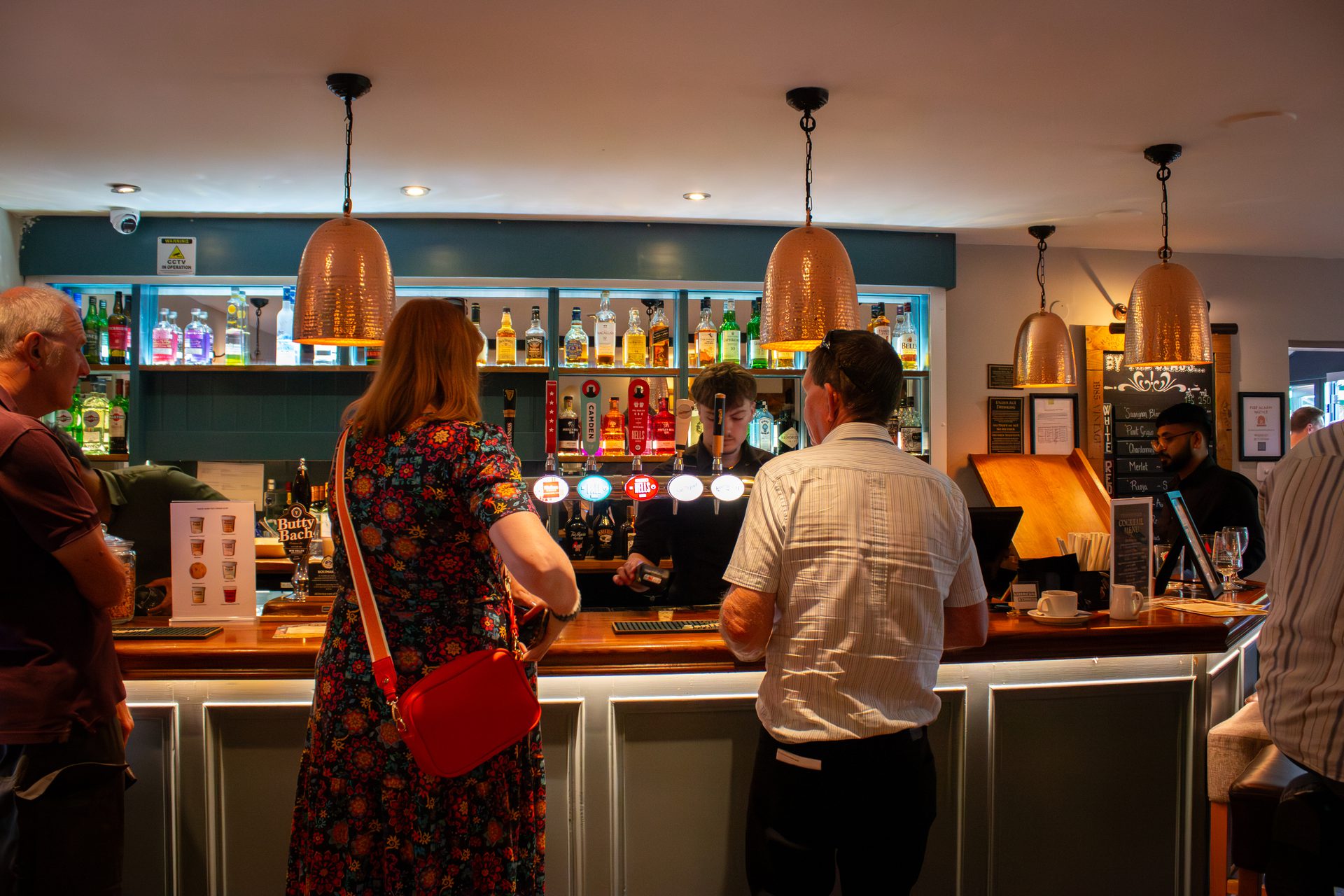Warm cosy bar interior with copper pendant lamps at The Twisted Boot