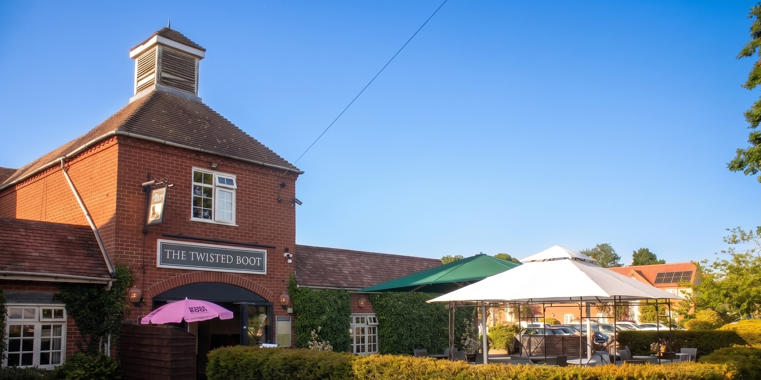 The Twisted Boot Bar exterior — a beautiful sunny day with guests enjoying drinks in the courtyard